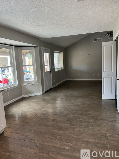 A room with wood flooring and a white door.