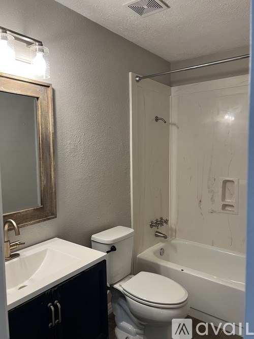 A bathroom with a toilet, sink, and bathtub.