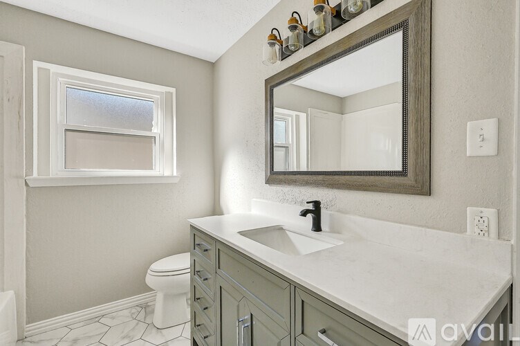 A bathroom with a white sink and a mirror above it.