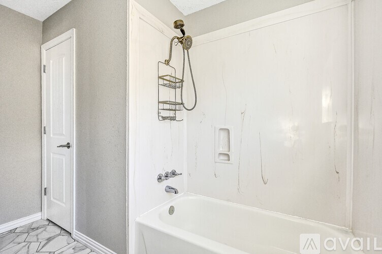 A white bathroom with a claw foot tub and a shower head.