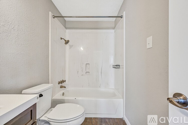 A white bathroom with a toilet, sink, and bathtub.