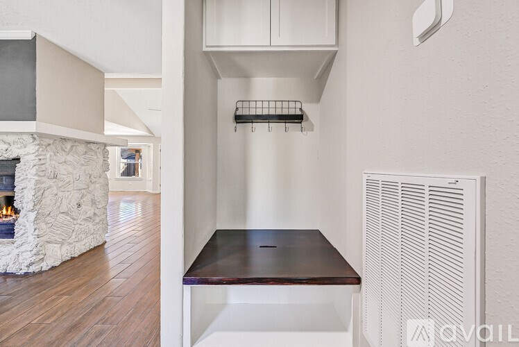A white room with a fireplace and a wooden floor.