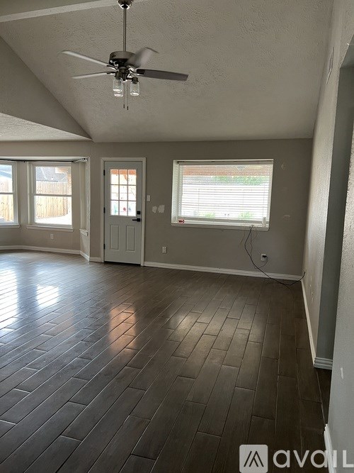 A room with a ceiling fan and wooden flooring.