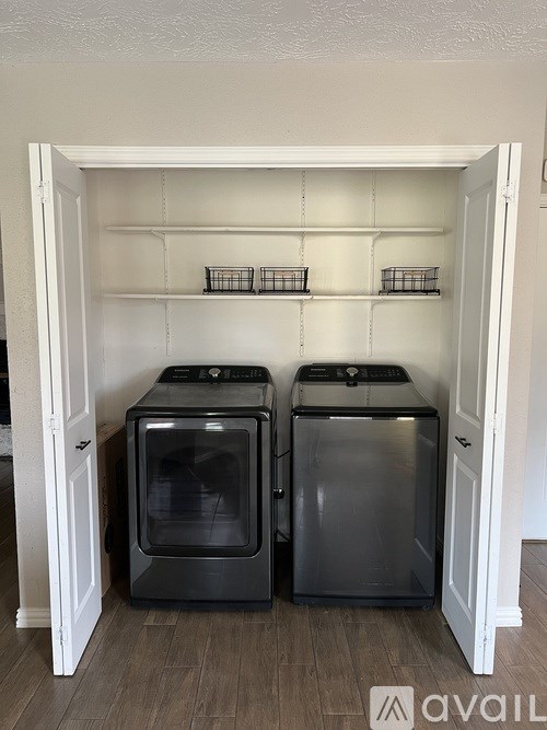 Two black ovens are in a white cabinet.