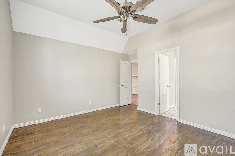 A room with a ceiling fan and a window with blinds.