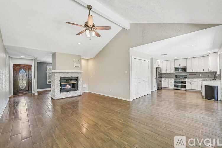 A room with a ceiling fan and a door.