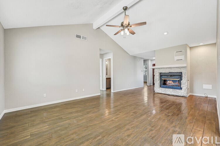A white door is open to a hallway with a black shelf and drawers.