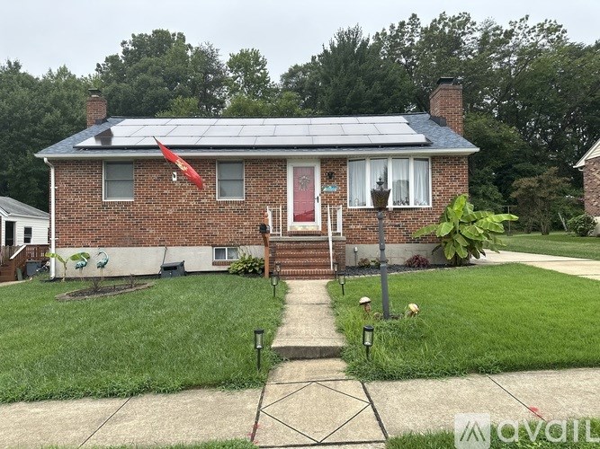 A house with a red door and a solar panel on the roof.