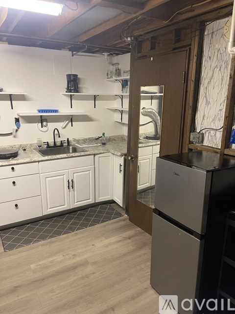 A kitchen with a refrigerator and a sink.