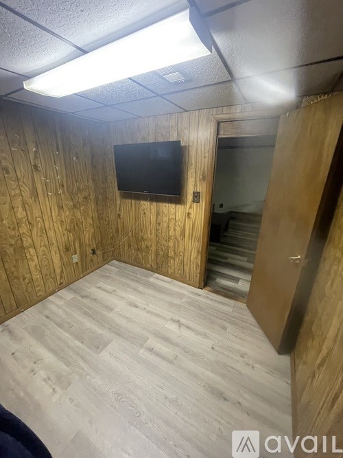 A room with wooden walls and a flat screen TV mounted on the wall.