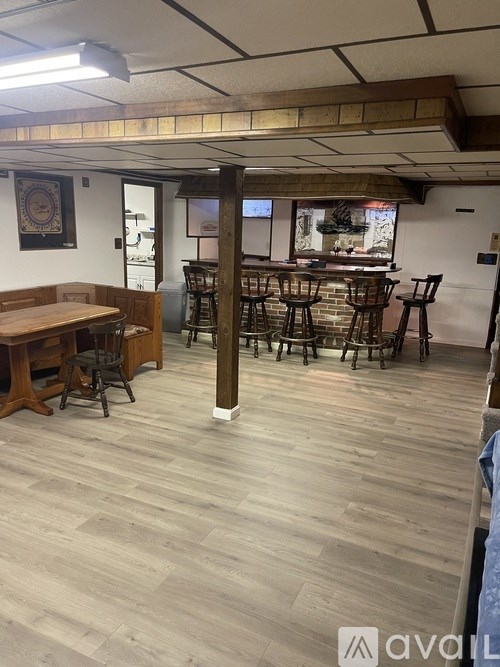 A room with wooden floors and a long table with chairs.