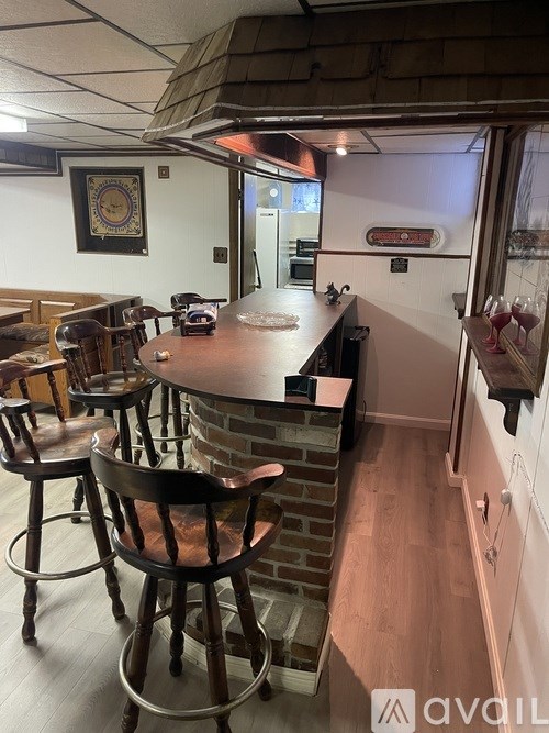 A bar area with a brick wall and wooden chairs.