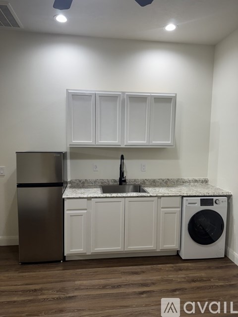 A kitchen with white cabinets and a marble backsplash.