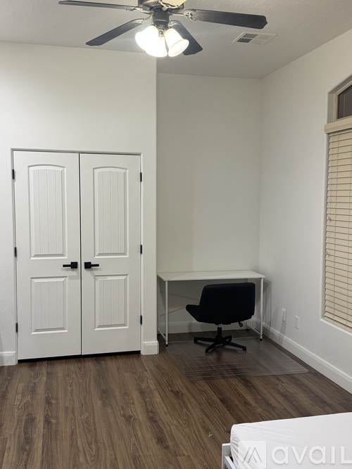 A room with a desk and a black chair.