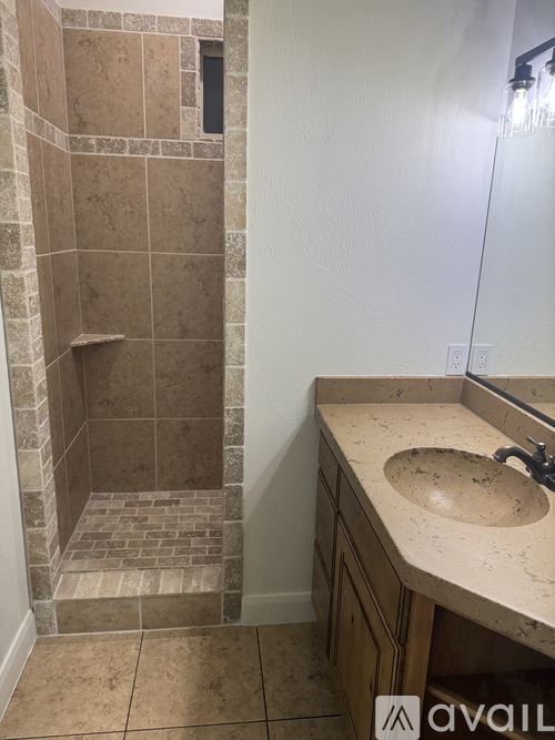 A bathroom with a tiled shower and a sink.