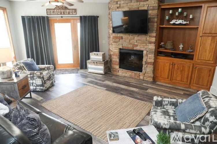 A living room with a fireplace and a television on the wall.