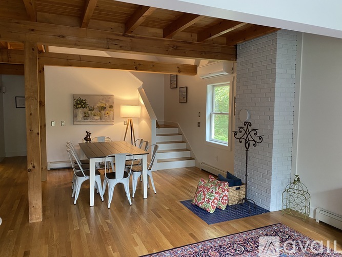 A dining room with a wooden table and chairs.