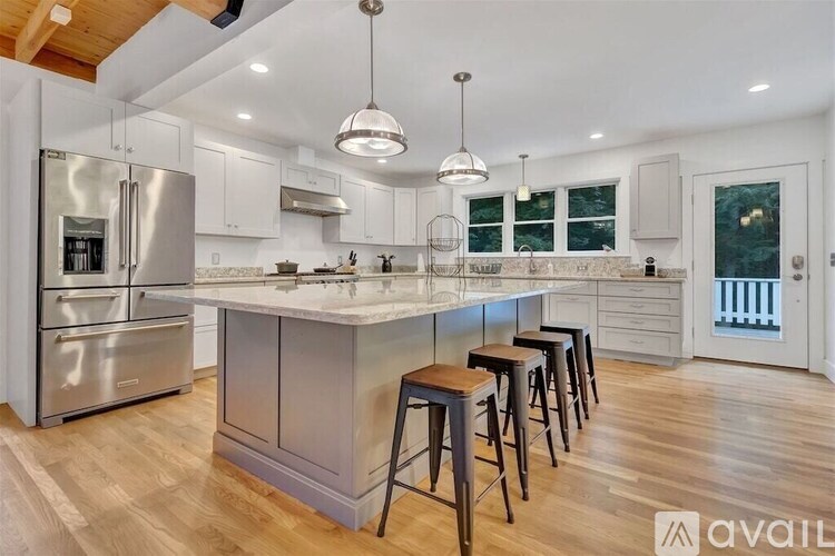 A modern kitchen with a center island and stools.