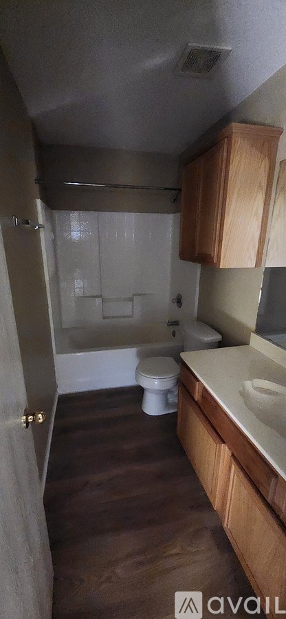 A bathroom with wooden cabinets and a white toilet.