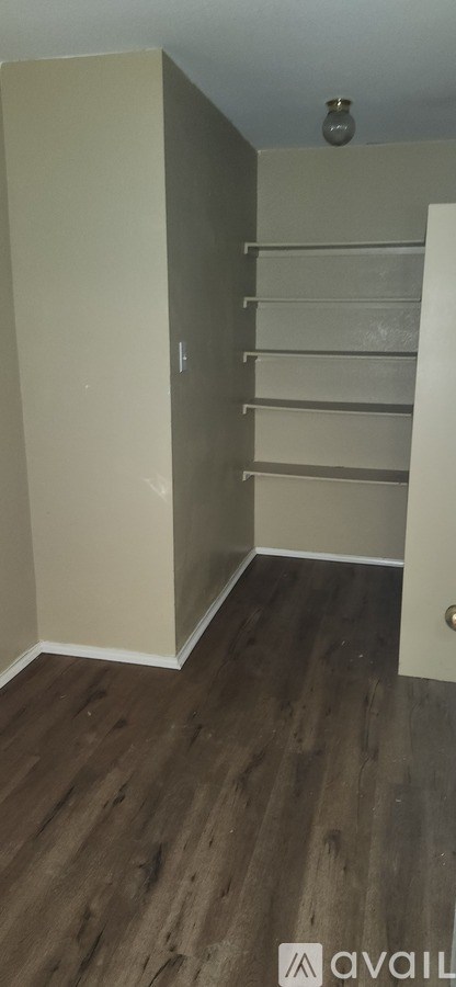 A room with a wooden floor and a white door.