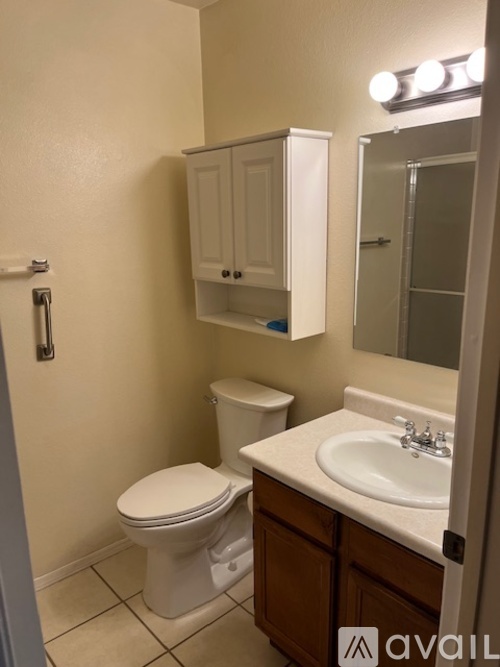 A bathroom with a toilet, sink, and medicine cabinet.