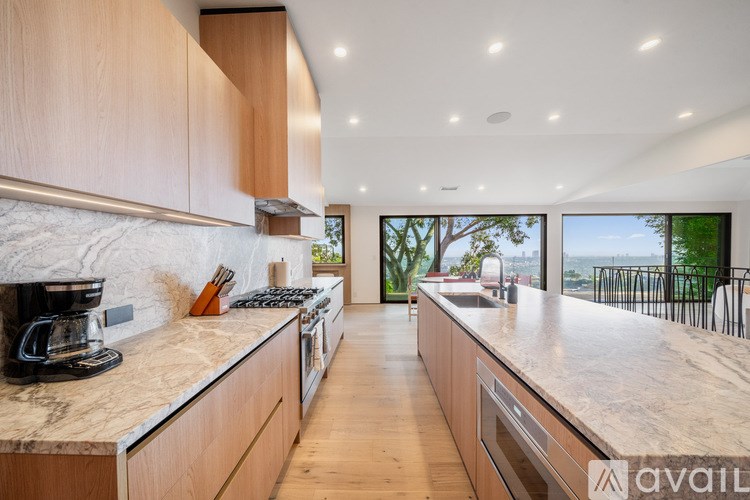 A kitchen with wooden cabinets and a marble countertop.