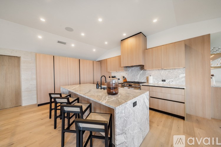 A kitchen with wooden cabinets and a marble countertop.