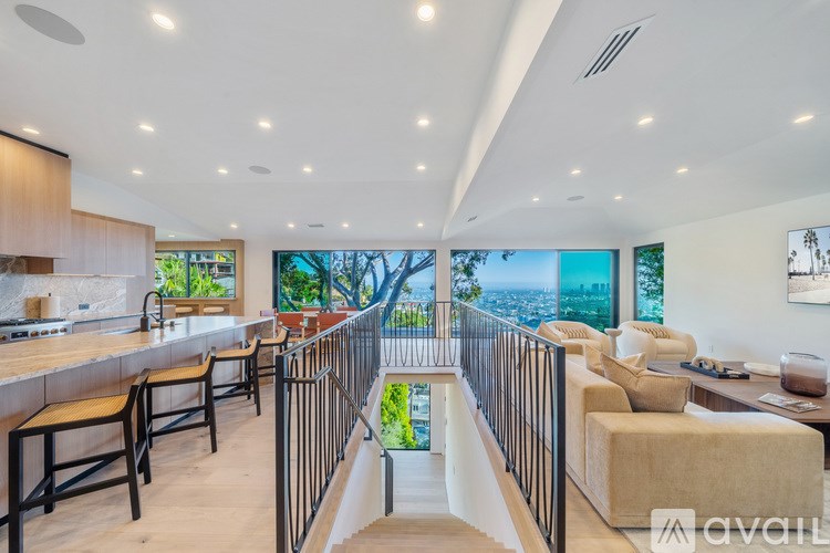 A spacious living room with a staircase leading to a balcony.