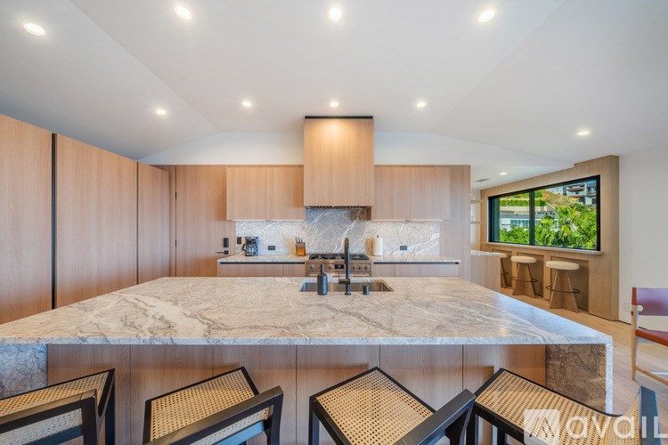 A modern kitchen with a marble countertop and wooden cabinets.