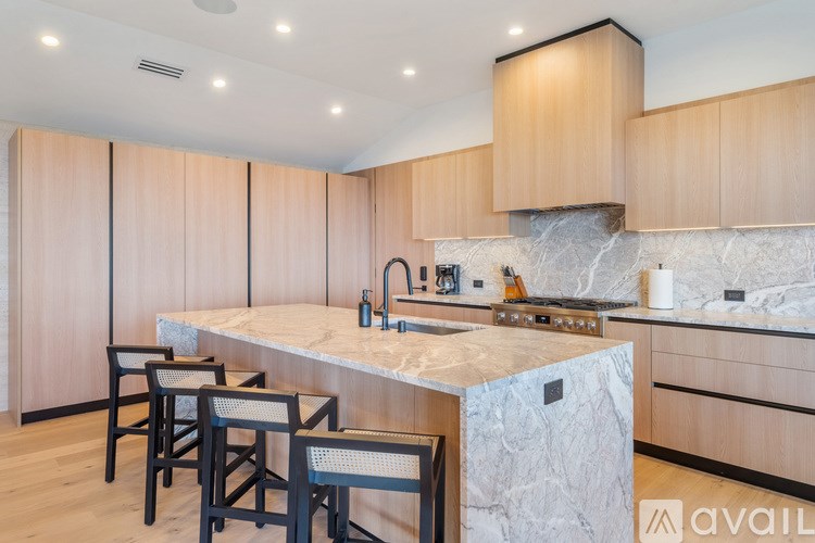 A kitchen with wooden cabinets and a marble countertop.