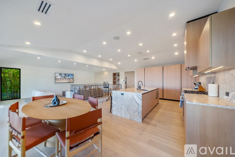 A modern kitchen with wooden floors and furniture.
