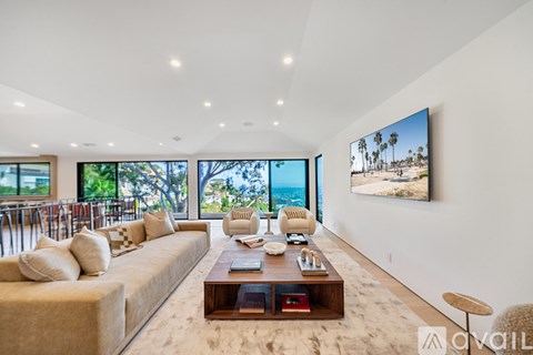 A living room with a large couch and a flat screen TV mounted on the wall.