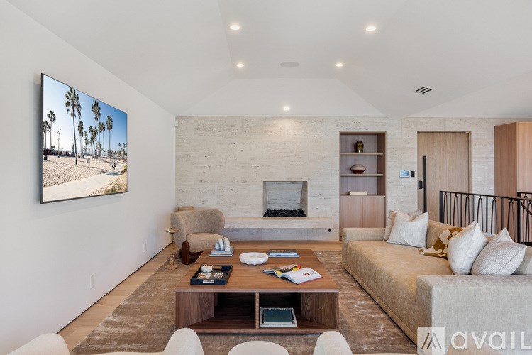 A modern living room with a large flat screen TV mounted on the wall.