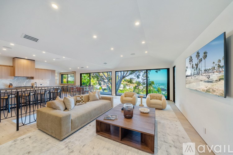 A modern living room with a large window overlooking a beach.