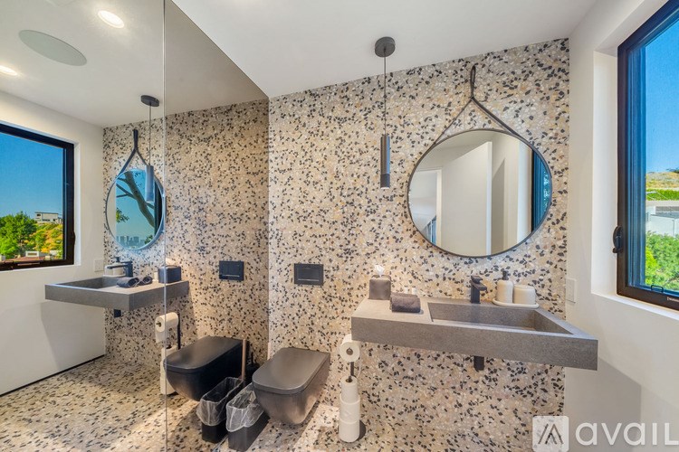 A bathroom with a large mirror and a sink with a window.