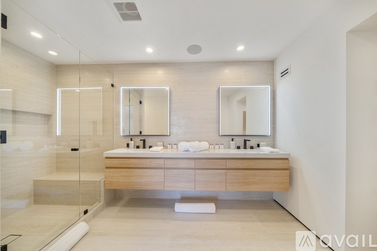A modern bathroom with a vanity and a glass shower area.