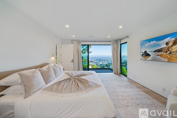 A bedroom with a large bed and a view of the city.