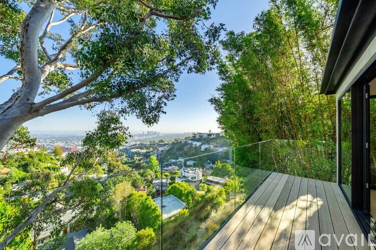 A wooden deck overlooks a cityscape with a clear blue sky above.