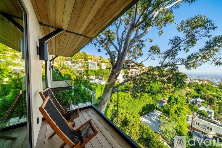 A balcony with a chair and a view of a residential area.