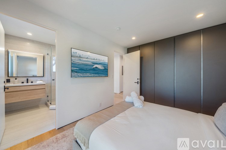 A bedroom with a large bed and a painting on the wall.