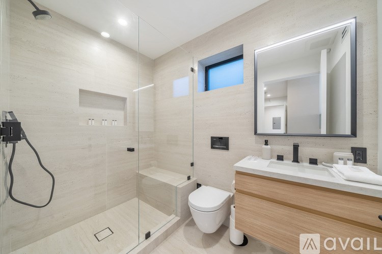 A modern bathroom with a walk-in shower and double sinks.