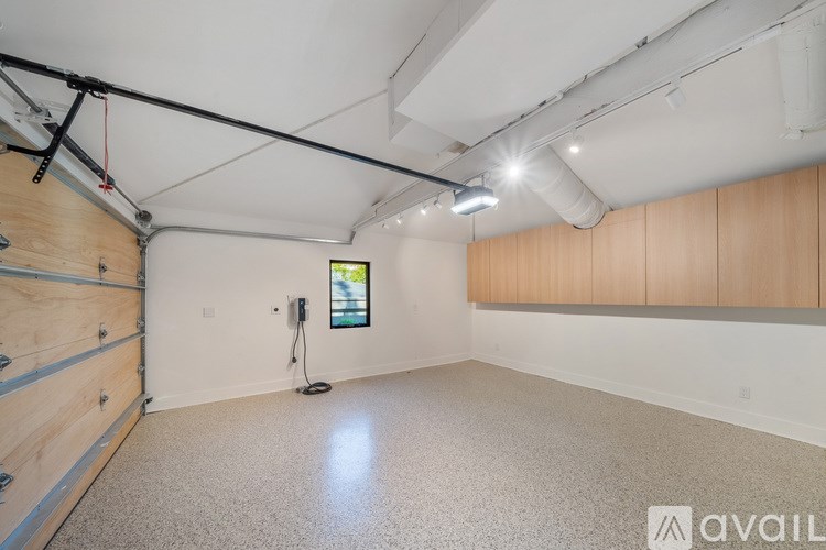 A spacious room with a concrete floor and a window on the wall.