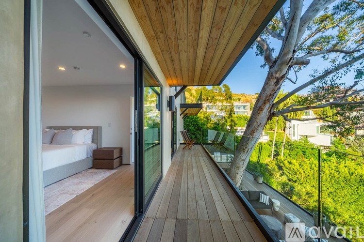 A modern house with a wooden deck and glass walls.