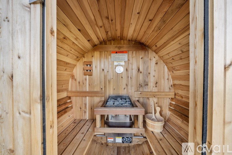 A wooden sauna with a bench and a bucket.