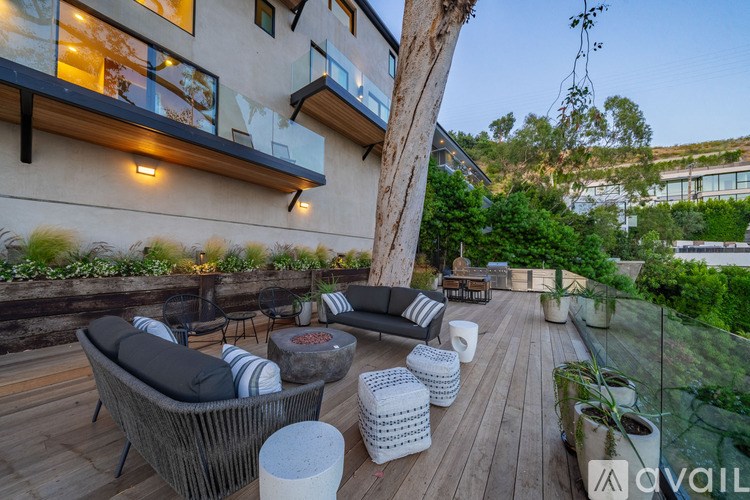 A patio with a wicker chair and table set up for outdoor dining.