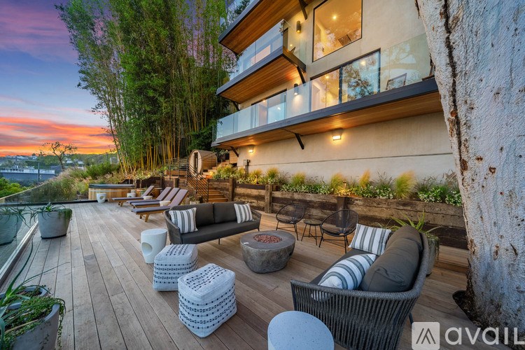A modern outdoor patio with a wooden deck and seating area.