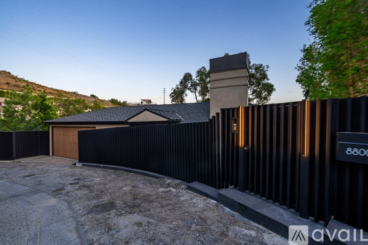 A house with a black fence and a chimney is shown.