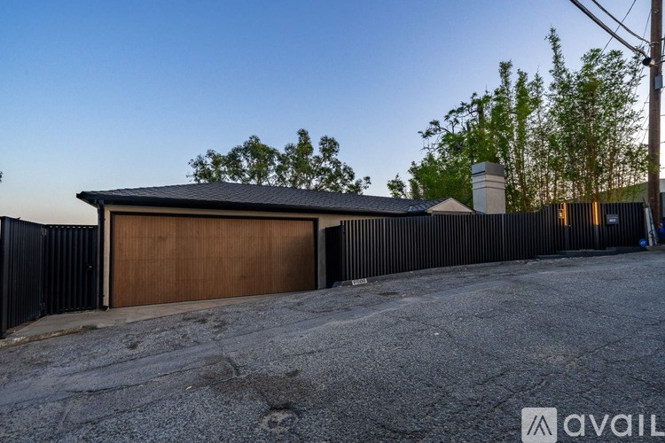 A house with a brown garage door and a black fence.