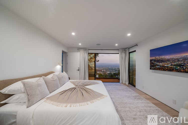 A bedroom with a large bed and a view of the city.