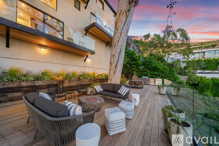 A patio with a wicker chair and table set with a view of a building.